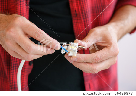 Male hands connect wires to extension plug Male hands connect wires to extension plug 66489878