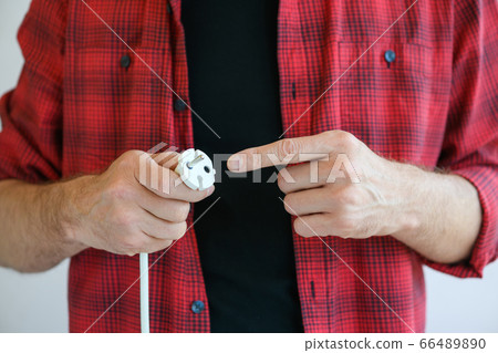 Finger point at electrical plug close up 66489890