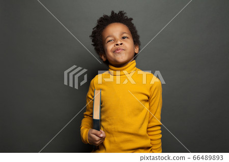 Funny kid boy holding book on chalkboard 66489893