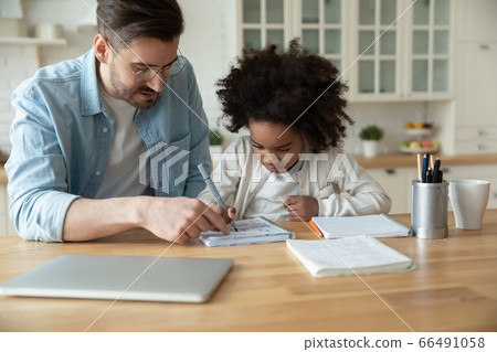 Caucasian stepfather helps with homework little mixed-race daughter Caucasian stepfather helps with homework little mixed-race daughter 66491058