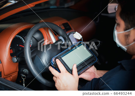 Checking a car engine OBD for repair at car garage Checking a car engine OBD for repair at car garage 66493244