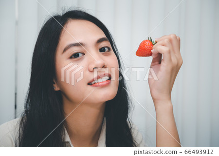 Woman eat strawberry red berry fruit sweet juicy 66493912