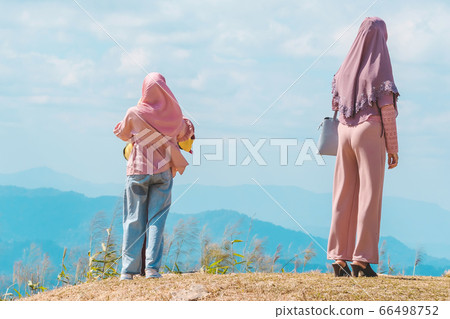 Back view of Muslim women wearing a Muslim dress and hijab enjoy on the highest point and the beautiful view landscape in morning at Elephant Hills View Point are located in Thong Pha Phum Kanchanabu Back view of Muslim women wearing a Muslim dress and hijab enjoy on the highest point and the beautiful view landscape in morning at Elephant Hills View Point are located in Thong Pha Phum Kanchanabu 66498752