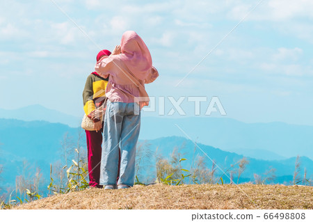 Back view of Muslim women wearing a Muslim dress and hijab enjoy on the highest point and the beautiful view landscape in morning at Elephant Hills  View Point are located in Thong Pha Phum Kanchanabu 66498808