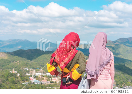 Back view of Muslim women wearing a Muslim dress and hijab enjoy on the highest point and the beautiful view landscape in morning at Elephant Hills View Point are located in Thong Pha Phum Kanchanabu Back view of Muslim women wearing a Muslim dress and hijab enjoy on the highest point and the beautiful view landscape in morning at Elephant Hills View Point are located in Thong Pha Phum Kanchanabu 66498811
