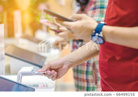 Close up to young man use the identification card inserted into the identity verification machine to receive ticket to the museum. Selective focus. 66499158
