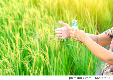 Woman using alcohol nano mist sprayer antiseptic cleaning on her hands protection during Coronavirus pandemic Covid-19.Hand using sanitizer spray.Modern health technology concept.New normal lifestyle. 66499387