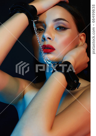 Girl in handcuffs. Beautiful young Woman in color Girl in handcuffs. Beautiful young Woman in color 66499638
