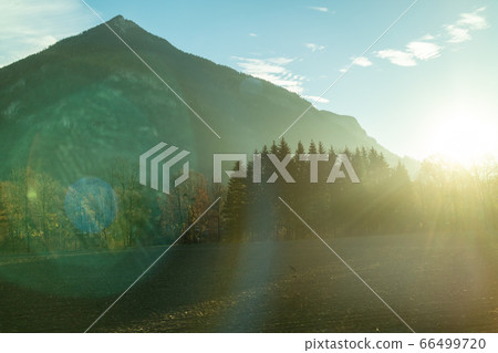 Mountain landscape with forest area on a background of sun light, Austria. Mountain landscape with forest area on a background of sun light, Austria. 66499720