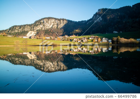 Beautiful landscape with country area near the lake and reflection in it. 66499786