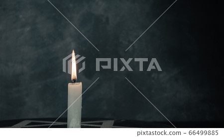 Close up one burning candles and the Star of David Close up one burning candles and the Star of David 66499885