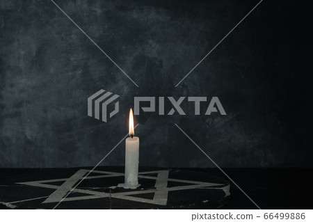 Close up one burning candles and the Star of David 66499886