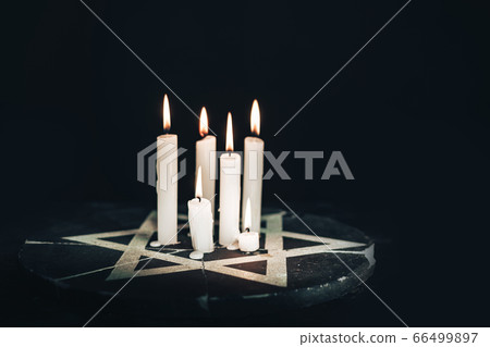 Six burning candles and the Star of David against Six burning candles and the Star of David against 66499897