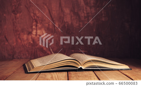 Beautiful ancient open old book on a red wooden Beautiful ancient open old book on a red wooden 66500083