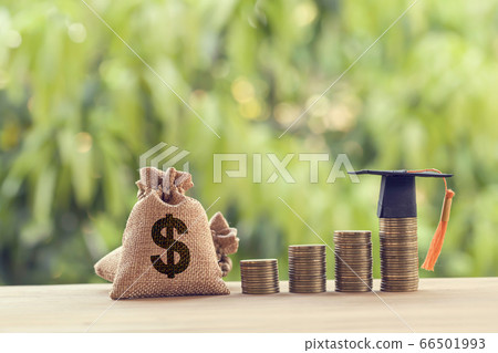 Black graduation cap, Hat and US dollar bag on rows of rising coins, on a table. Education funding, financial concept. Depicts savings for child knowledge for future studies Black graduation cap, Hat and US dollar bag on rows of rising coins, on a table. Education funding, financial concept. Depicts savings for child knowledge for future studies 66501993