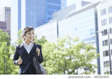 Young business woman running in the office district Young business woman running in the office district 66502002