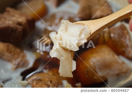 Remove the fat from the boiled pork with a spoon 66504887