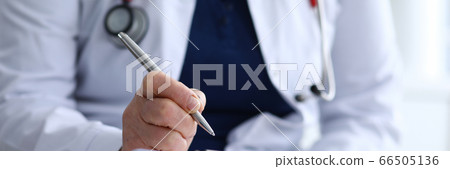 Experienced doctor in white coat takes notes Experienced doctor in white coat takes notes 66505136