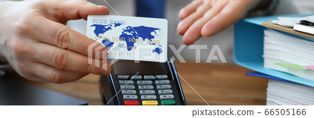 Man holds credit card in his hand, near terminal Man holds credit card in his hand, near terminal 66505166