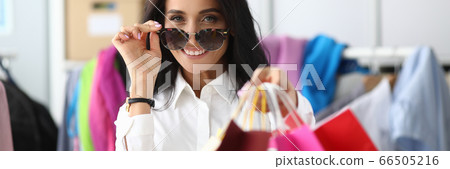 Woman adjusts glasses from sun showing packages 66505216