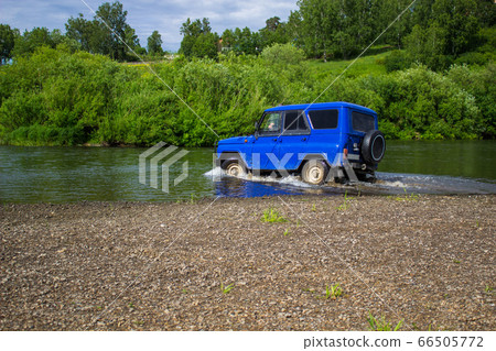 Car SUV UAZ rides on the river. Car SUV UAZ rides on the river. 66505772