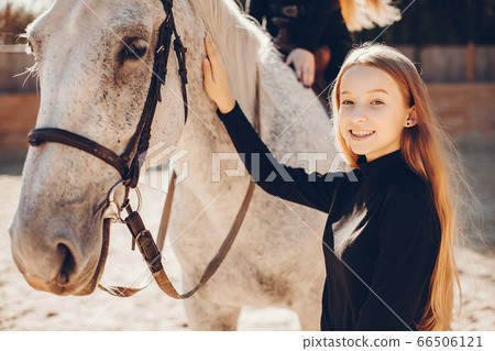 Elegant girls with a horse in a ranch Elegant girls with a horse in a ranch 66506121