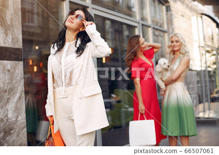 Three elegant women with shopping bags in a city 66507061