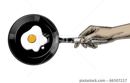 A woman cooks eggs in a frying pan. 66507217