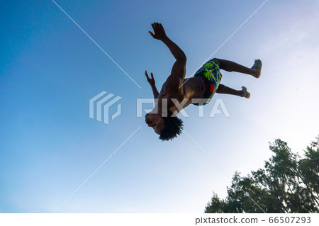 Young Attractive Muscular and Strong Athletic Black African Man at the White Sand Beach Training Acrobatics and Jumping Gymnastics Beach Performance Young Attractive Muscular and Strong Athletic Black African Man at the White Sand Beach Training Acrobatics and Jumping Gymnastics Beach Performance 66507293