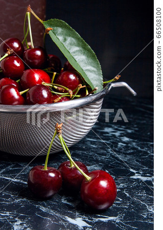 Several red sweet cherries and big green leaf on Several red sweet cherries and big green leaf on 66508100