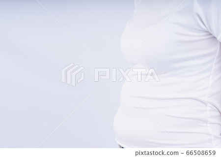 Close-up woman showing excessive belly fat, 66508659