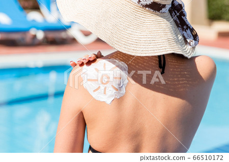 Beautiful woman with drawn sun by sun cream on her Beautiful woman with drawn sun by sun cream on her 66510172