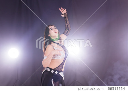 Portrait of a woman in oriental costume performing belly dance. Tribal fusion dance concept. Copy space. Portrait of a woman in oriental costume performing belly dance. Tribal fusion dance concept. Copy space. 66513334
