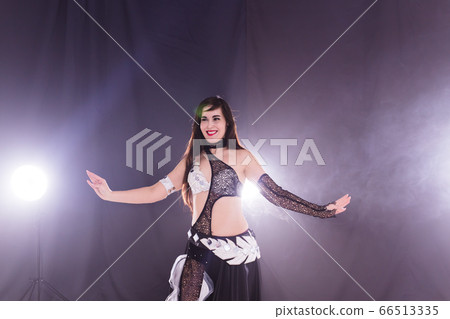 Belly dancer. Young attractive woman dancing tribal fusion on the stage. Oriental exotic dance. Belly dancer. Young attractive woman dancing tribal fusion on the stage. Oriental exotic dance. 66513335