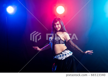 Girl dancing belly dance, fusion or tribal. A woman in a beautiful costume demonstrates charming and gentle movements in the dance. 66513340