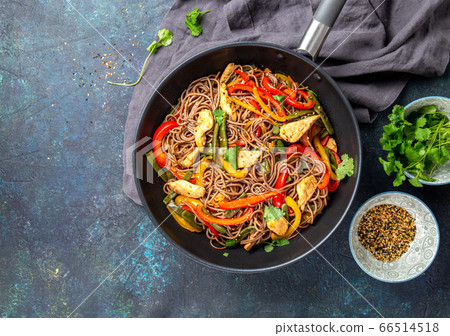 Japanese dish buckwheat soba noodles with chicken and vegetables carrot, bell pepper and green beans in wok on dark blue background 66514518