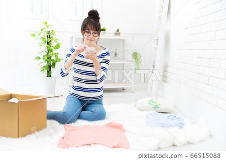 A woman preparing to sell clothes that are no longer used online 66515088