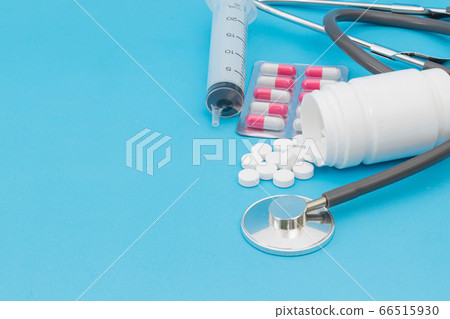 Tablet medical stethoscope and injection on a blue background Tablet medical stethoscope and injection on a blue background 66515930