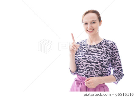 A young woman in plain clothes pointing at a point 66516116