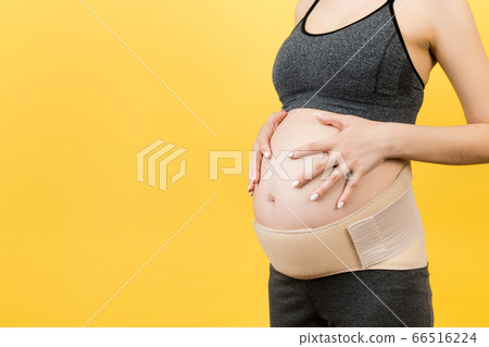 Cropped image of pregnant woman wearing elastic Cropped image of pregnant woman wearing elastic 66516224