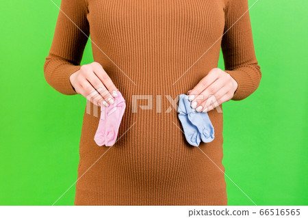 Cropped portrait of pregnant woman in brown dress Cropped portrait of pregnant woman in brown dress 66516565