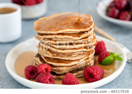 Syrup pouring on stack of whole wheat pancakes Syrup pouring on stack of whole wheat pancakes 66517038