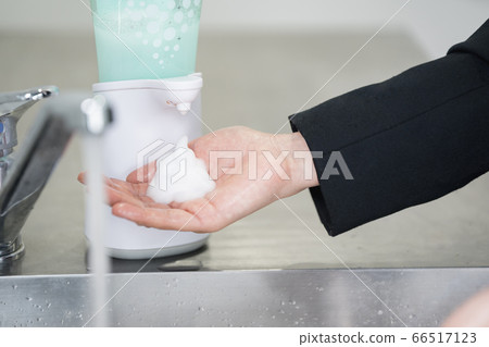 Woman in suit washing hands Woman in suit washing hands 66517123
