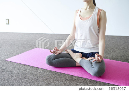 Young Japanese woman doing yoga in the room 66518037