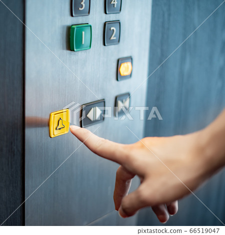 Male hand pressing on emergency button in elevator 66519047