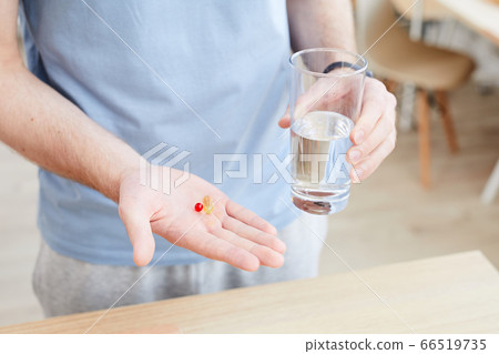 Man drinking vitamin pill 66519735