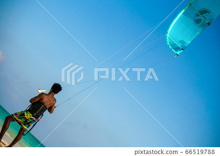 Young Attractive Muscular and Strong Athletic Black African Man Kite Surfing Instructor Teacher at the White Sand Beach Young Attractive Muscular and Strong Athletic Black African Man Kite Surfing Instructor Teacher at the White Sand Beach 66519788