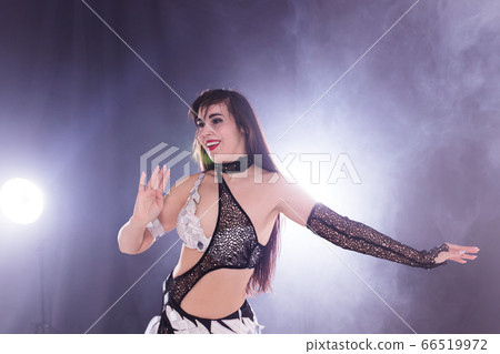 Young woman dancing in Tribal Fusion style. Belly dance on the stage. Young woman dancing in Tribal Fusion style. Belly dance on the stage. 66519972