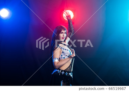 Young woman belly dancer in exotic dress with gold, dancing tribal fusion dance in studio. Copy space. Young woman belly dancer in exotic dress with gold, dancing tribal fusion dance in studio. Copy space. 66519987
