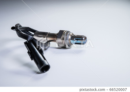 The oxygen sensor is a new lambda sensor. Spare parts on the car on a gray gradient background 66520007